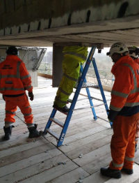 Engineers climb to reach an access hatch underneath the Clifton Bridge. Click to enlarge
