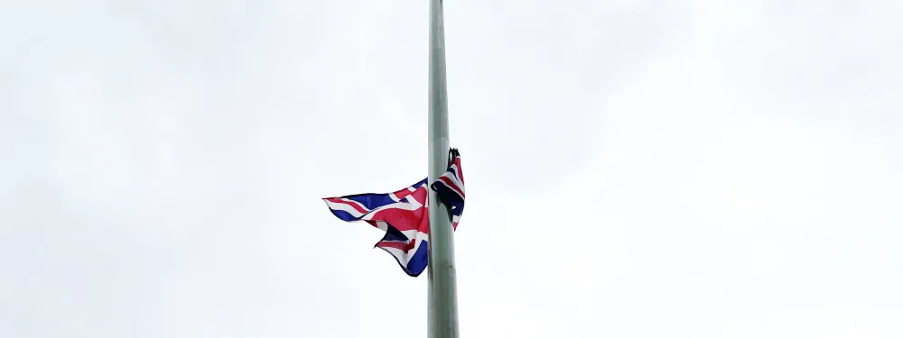 A union jack attached to a lamp post, seen against a grey sky