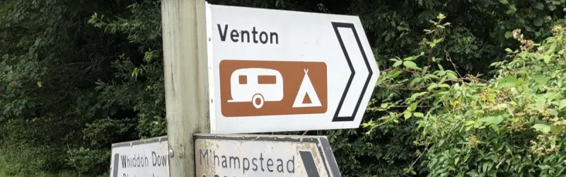 A white sign, complete with white arrow, for a very local road. Click to enlarge