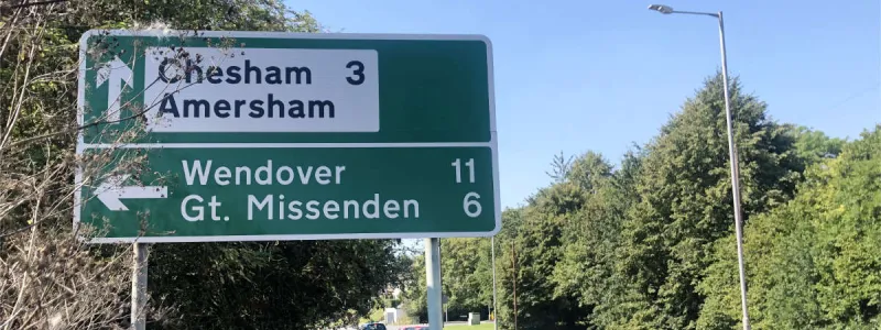 Not a blue border in sight: a modern local direction sign, separate to the main sign for the junction and in colours matching the routes. Click to enlarge