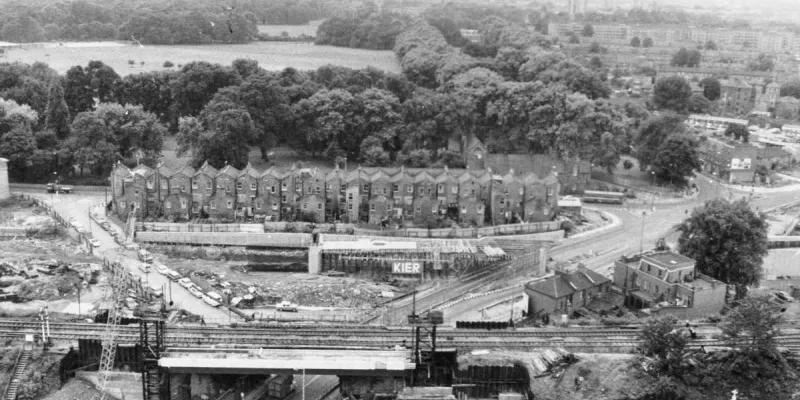 A flyover forming part of the East Cross Route (now the A12) under construction at Hackney Wick in 1971. The houses, on Cadogan Terrace, are still there, now backing on to a major dual carriageway. Victoria Park is in the distance. Click to enlarge