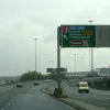 As we pass over the top of junction 2, there's the first sign of junction 3 — with its number on a huge red patch — mounted on the back of a gantry sign on the opposite carriageway.