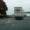 The lorry driver isn't following the signs. On the Ring Road, normal lane discipline doesn't apply; if you're not turning off you keep right to make room for the poor souls who are. He's keeping left, as you would anywhere else, and seems to be making life difficult for the black car trying to pull out.