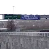 Through the tolls and heading south again on the A41, this enormous sign gantry is original to the 1960s remodelling of the tunnel mouth. The sign at the far right has been modified as the flyover had two lanes, which split in two, until the early 1990s when one branch was demolished. In the foreground is the retaining wall for the A41 underpass.