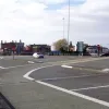 The remodelled toll plaza features enormous "marshalling areas", intended to stack queueing traffic efficiently. The complex signalling system never worked properly, and was dismantled long ago. Now these areas are just vast empty spaces in the town centre. A bus lane has been painted all over this one.