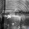 January, 1929: the "mechanical erector" is used to place the cast-iron tunnel lining sections in place. It appears to be a lifting arm that rotates and extends in order to lift a piece of lining and push it into place for fastening. The incredible size of the tunnel and equipment is only clear when you realise there are several tiny people in the foreground and working on top of the machinery.