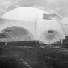The completed tunnel shortly before opening in 1934, with the lofty junction chamber near the Birkenhead end. To the rear, the main bore runs to Liverpool; ahead the tunnel splits with one four-lane branch to Birkenhead and one two-lane branch to Rendel Street. The latter was closed in 1965. Note the direction signs suspended above the roadway and the lack of traffic control.