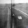 Liverpool was the second city of the United Kingdom in 1934 and the largest port in the British Empire, and as such was undergoing enormous development. As well as the Queensway Tunnel, it also received the Liverpool to East Lancashire Road, one of the first new inter-city roads built in Britain, which opened in the same year.  This (unfortunately faded) image shows its original state, with three unmarked traffic lanes crossing the Lancashire countryside.