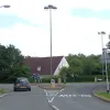 This miniature roundabout is typical of many within the residential districts, though busier routes and industrial areas tended to have larger examples. It has an attempt at feature lighting, and is actually used here as a gateway to the 'centre' of one of the residential areas, intended to slow traffic approaching the school and shops.