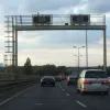Lane control signals - managing to look even more spindly and temporary than the road itself. Where does the ladder on the left hand side take you?