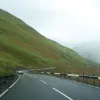 There's a bit of a mountain pass here, cutting through a low point in the hills and dropping sharply at the far side. It looks like that mist is still lingering around on the high ground. In the other direction, a line of cars followed a struggling camper van up the hill.