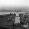Looking west from the top of the tower on the Beachley side, the section across the Beachley peninsula is visible, leading to a gap where the Wye Bridge now stands. The section in the foreground is still in England; Wales lies across the Wye in the distance.