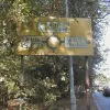 Approaching from the south is another sign, mostly obscured by trees and decidedly mossy. Nonetheless it's in good condition too.