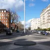 The remaining part of the street, leading up to Hyde Park, is still a dual carriageway, and here the circular islands and tall masts mark the central reservation. Parked cars line the edges, and apart from the striking pavement design, this is effectively just an urban dual carriageway.