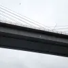 Modern bridge design has new ways of dealing with the wind. The bridge deck is totally enclosed and looks reassuringly solid, and the joins between the pre-fabricated sections that were towed into the river and hoisted into place can now barely be seen. Tall barriers shield traffic from the wind.
