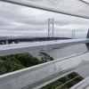 Up close - again, not a view that's easily possible from a moving vehicle - the Forth Road Bridge is framed between the clear plastic beams of the wind barrier.
