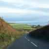 Lush, rolling hills dotted with sheep can be glimpsed between the high hedges, where it's safe to take your eyes off the twisting and curving road.