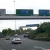 Gantry signs just before the split date from before the junction's redevelopment and the motorway's redesignation to M621. The sign in the middle still thinks the M1 connects to the junction.