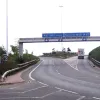 The lanes bound for the motorway network climb steeply and split. The ones to the left head towards the M1, dropping quite suddenly after the brow of the hill, while the ones to the right continue on a high viaduct to pass over the top of the motorway towards the M62.