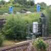 The railway between Leeds and Pontefract passes beneath the interchange. Across it, signs are visible on the westbound M621 showing the lane drop in advance of the merge with traffic leaving Leeds on the viaduct.