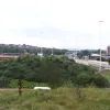 The never-used embankment in the middle of the gyratory system is surprisingly tall and gives a broad view of the motorway interchange that lies to the south. On the right the new railway bridge is visible carrying the exit from the M621 eastbound towards the city centre.