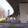 In the other direction, the A57 dual carriageway runs below the Mancunian Way to the next roundabout, curving away into the distance.