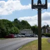 The dual carriageway is the Mickleham Bypass, but its location is constrained by the river Mole and so it skirts the northern edge of the village here, with some houses and businesses fronting on to the southbound carriageway. The road is still restricted to one lane.