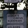 Another lovely pre-Worboys sign, this time on a traffic island in the middle of Aldwych, on its western arm. Notice the unusual road name sign above it. It was removed in late 2009, but the semi-circular name plate above it remains.  Photo by Tony