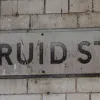 Here's an old street name sign that incorporates the road number. A black vertical bar separates the two (and someone has fixed a cable across the sign, over the road number!).  Photo by Tony