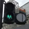 In place of the green man is a new symbol — two women, hand in hand, with a heart between them.