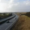 Looking north from the footbridge, a similar view as expected. Except that by the time traffic reaches the right-hand bend further up the road, it is a motorway. There is clearly no exit from the road between here and there.