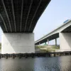 Both Viaducts curve slightly to the left when facing north. Though it's virtually invisible on the road, from underneath, it's clear that the deck is tilted slightly to provide some banking. The new Viaduct has angled piers, but this view shows that the old Viaduct has three bearings higher than the rest on top of each pier. Look closely at the beams emerging on the right hand side.