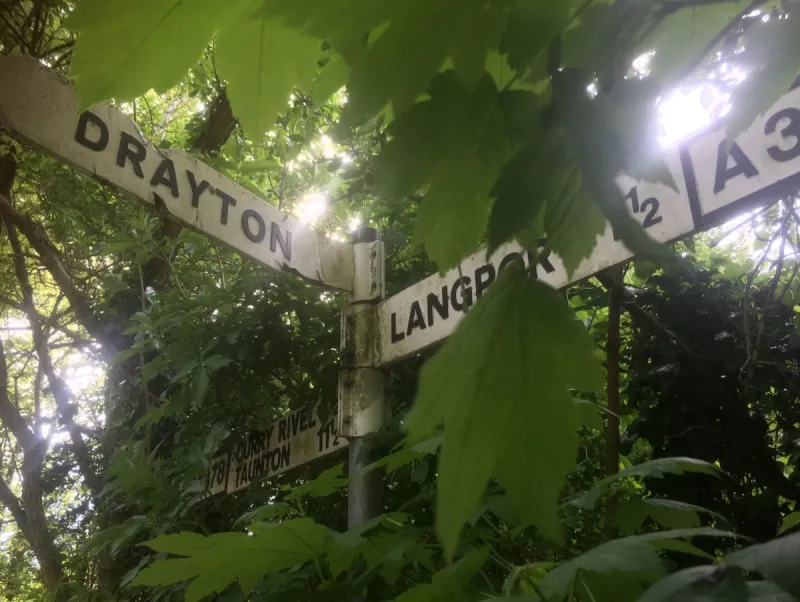 On the road between Langport and Curry Rivel, this signpost is hidden by the trees. This is notable as it has the road number on it; surprisngly few do! All three arms here are reproductions, with two in modern “Transport” lettering.