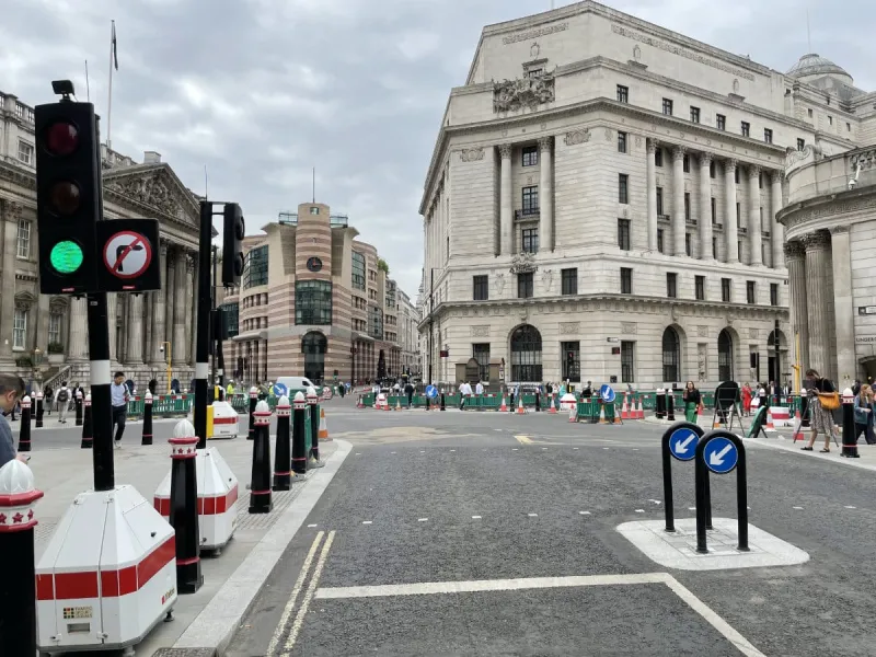 The junction seen from the east, with Mansion House visible on the left and a corner of the Bank of England on the right. Roadworks are in evidence all around the junction to narrow the streets that were once made as wide as possible, in an era when road numbers encouraged through traffic here. Click to enlarge